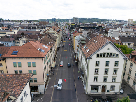 Aerial view of historic buildings and a straight city street with light traffic under a cloudy sky in Biel Bienne Canton of Bern Switzerland. Aerial view of historic buildings and a straight city street with light traffic under a cloudy sky in Biel Bienne Canton of Bern Switzerland.
