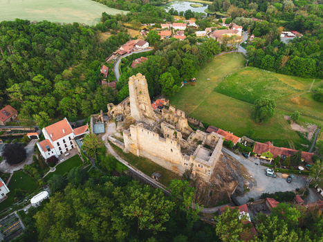 Aerial view of the historic ruins of Okor Castle surrounded by lush green trees and rolling hills in Okor Central Bohemian Region Czechia. Aerial view of the historic ruins of Okor Castle surrounded by lush green trees and rolling hills in Okor Central Bohemian Region Czechia.