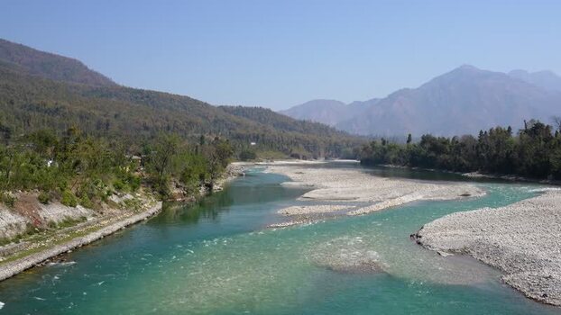 View of a wide turquoise river flowing through a valley Nepal.