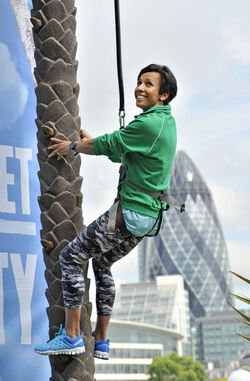Dame Kelly Holmes climbs up a 23ft coconut tree at the Vita Coco Coconut Grove in Potters Fields London