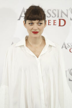 Pregnant Marion Cotillard covers her bump in a loose white Area shirt as she poses with Michael Fassbender at the Assasin s Creed Photocall Madrid