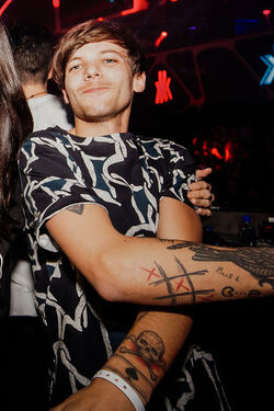 One Direction Member Louis Tomlinson shows off his tattoos as he is spotted at Hakkasan Nightclub