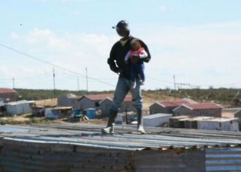 Heart stopping moment South African dad throws his own toddler off roof in protest at illegal shack being demolished Heart stopping moment South African dad throws his own toddler off roof in protest at illegal shack being demolished