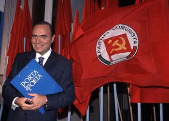 BRUNO VESPA GIORNALISTA E CONDUTTORE TELEVISIVO DAVANTI ALLE BANDIERE DEL PARTITO COMUNISTA