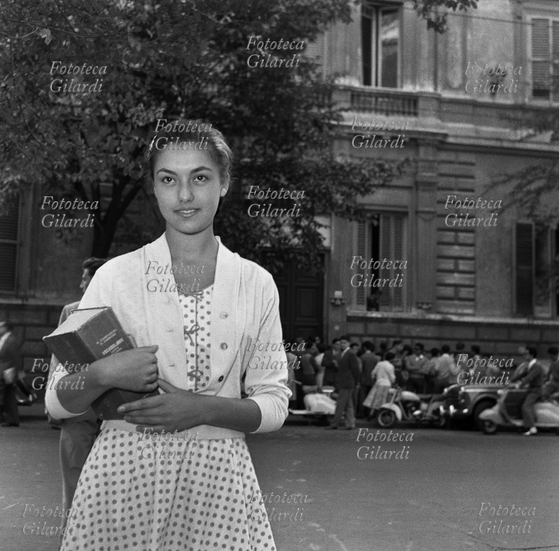 SCUOLA Studentessa sorridente, con il vocabolario in mano, attende l\