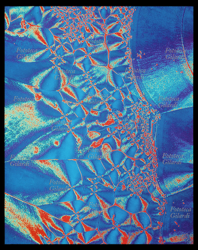 COLORI ARBITRARI elaborazione cromatica di una macrofotografia della struttura esagonale prodotta da bolle di sapone. Toni di cyan, blu, rosso, bianco. Il sofisticato procedimento di colorazione creativa arbitraria è stato ideato dall\