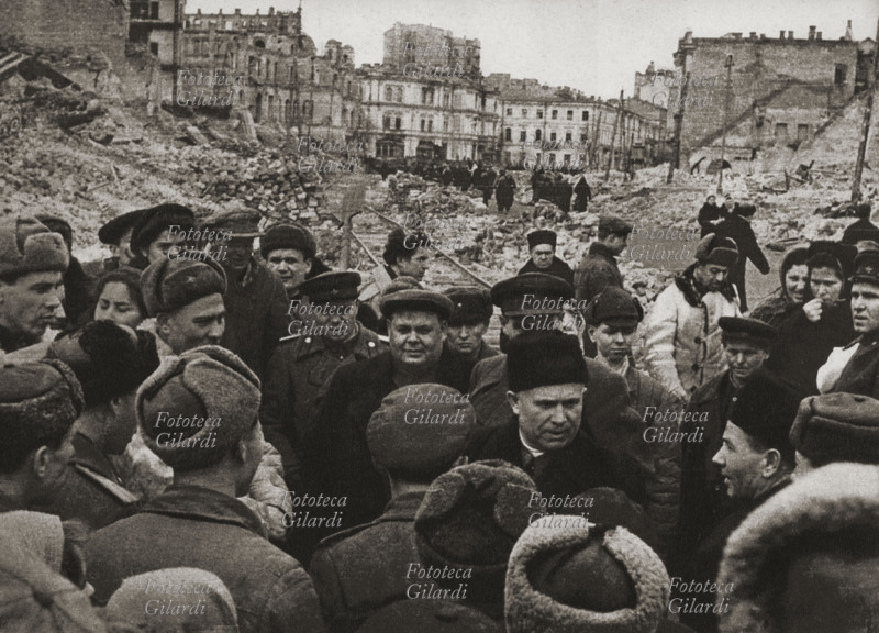 Nikita Sergeevic KRUSCEV (1894-1971) tra la popolazione e alcuni soldati nella città di Kiev distrutta dai bombardamenti. URSS marzo 1944