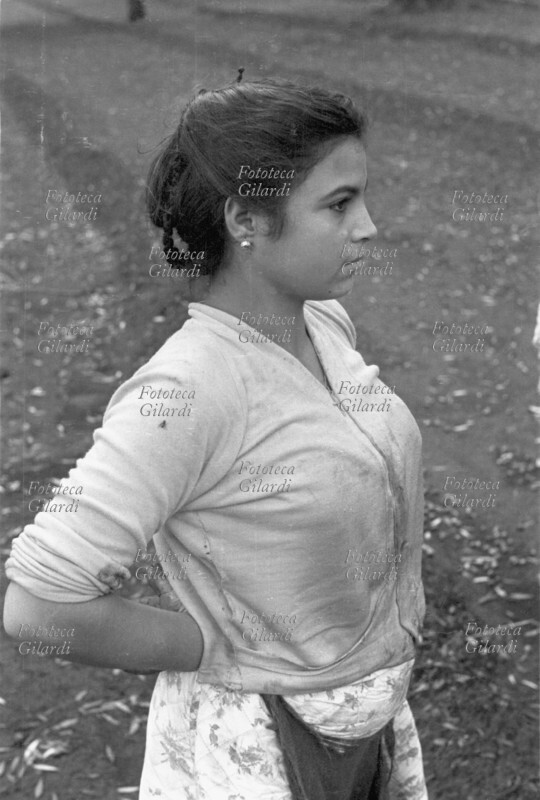 AGRICOLTURA giovane e graziosa raccoglitrice di olive calabrese, ripresa di profilo a mezzo busto nell\
