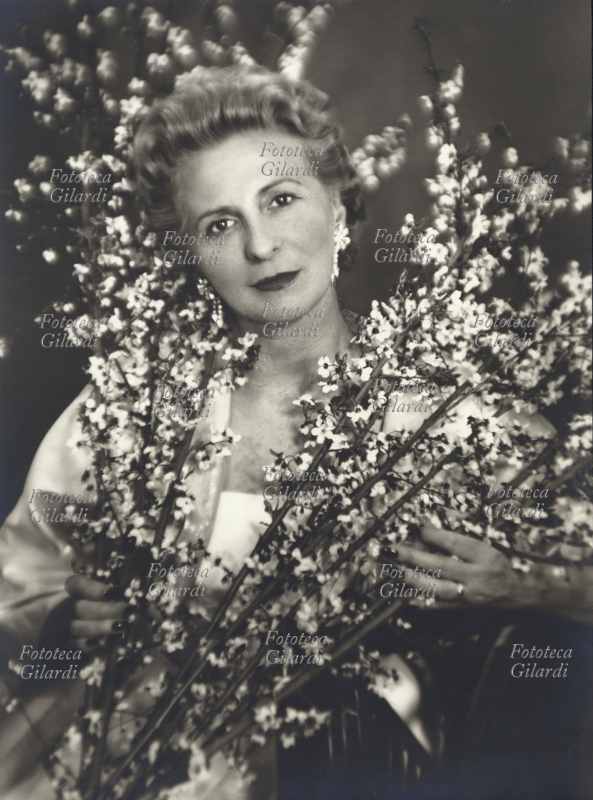 Principessa Marcella BORGHESE (15 February 1911 - 19 January 2002), born Marcella Fazi, entrepreneur, founder of the luxury cosmetic line (subsidiary of the multinational Revlon) that bears her name, second wife of Prince Paolo Borghese. Photographic portrait sitting with twigs in bloom performed by Ghitta Carell (20 September 1899 - 18 January 1972), the official photographer of the royals of Italy and author of the most appreciated portraits of the eminent personalities of the regime, who continued to perform in the years after the war portraits of the characters of Roman culture, politics, nobility and bourgeoisie. Italy, around 1948