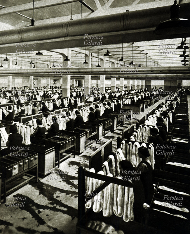 HISTORY Of the Panoramic INDUSTRY of the inside of a textile mill: cars and laborers to the job. Italy 1930 approximately.