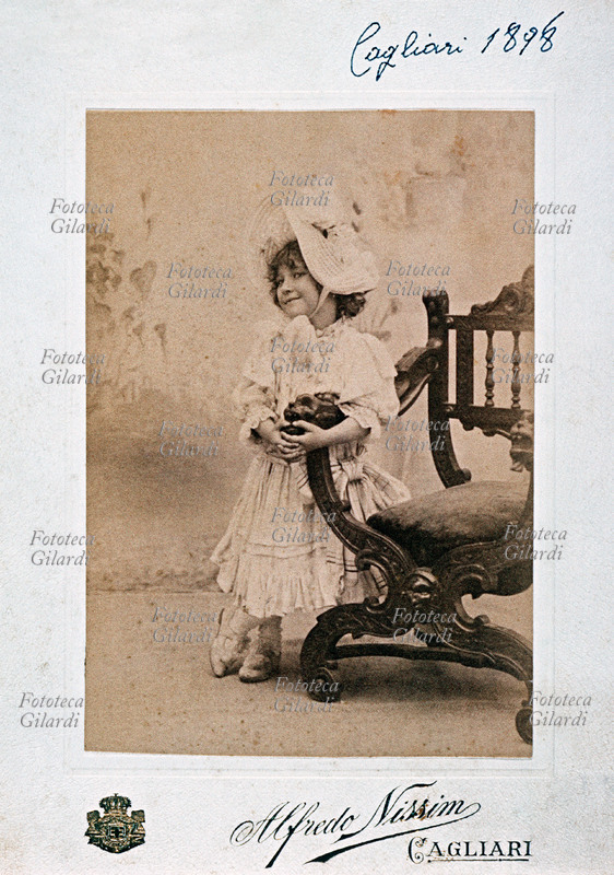 BAMBINI Ritratto fotoricordo di elegantissima bambina, con ricco vestito e cappello chiaro decorato con pizzi e \