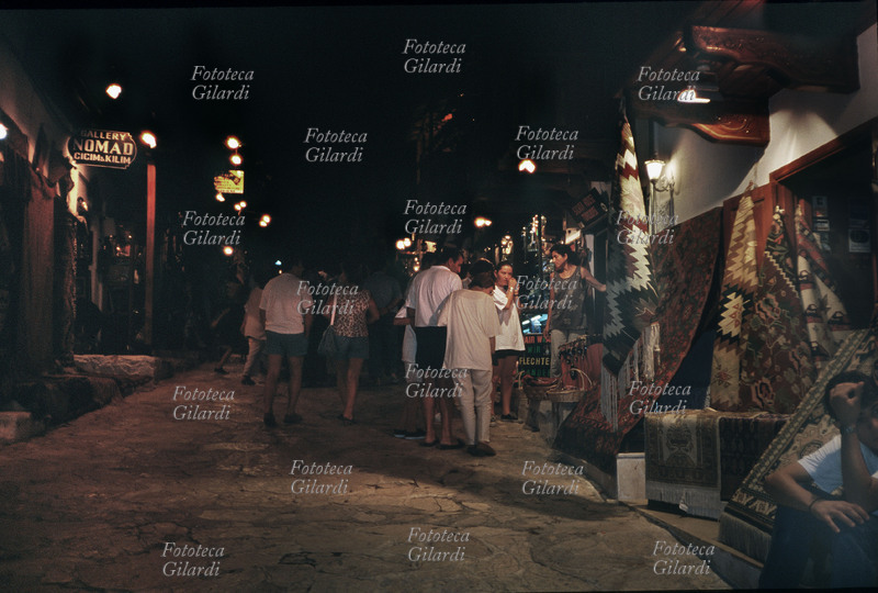 COMMERCIO bottega di venditore di tappeti in Turchia a Ras. Nelle ore notturne più fresche i turisti comprano i manufatti locali. turchia 1997