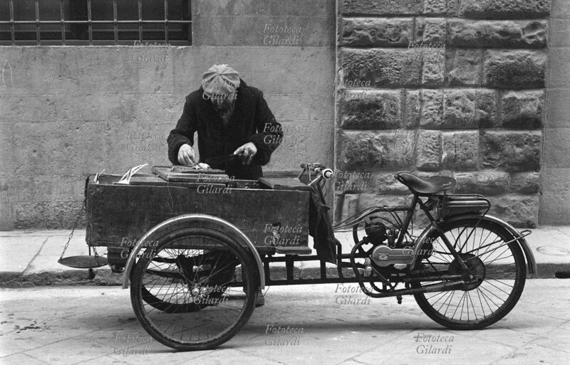 AMBULANTI il carretto del venditore ambulante di trippa bollita per gatti gira nelle strade tra le clienti abituali. Fotografia di Ando Gilardi (1921 - 2012) #andogilardi, Empoli 1950-60.