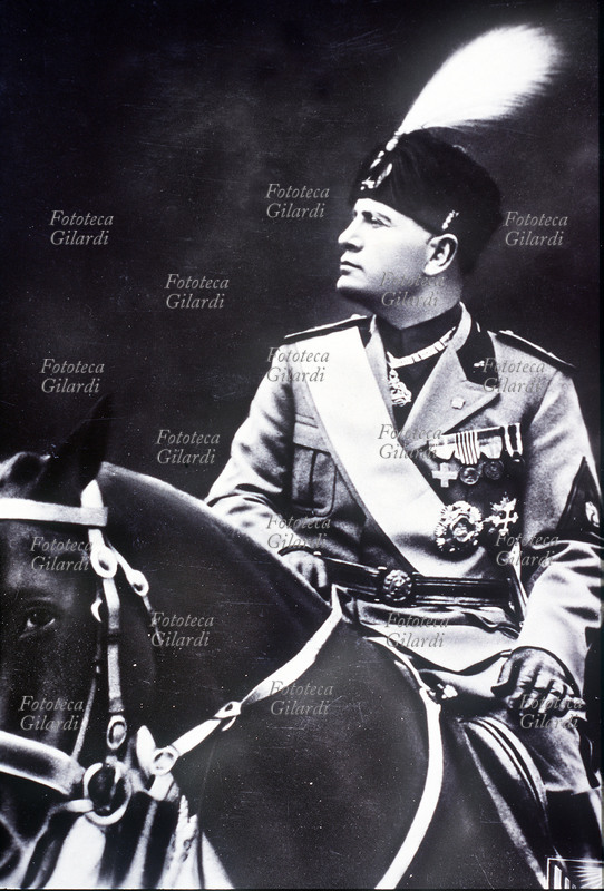 Benito MUSSOLINI official portrait to horse in high uniform. Photography distributed to the students of Leonardo da Vinci at the beginning of the school year October XIII (1936), to Milan. On the back the following dedication: “Little ones comrades, than in this decisive hour of the Native land begun (...) the fascists of the touched Tonoli greet in you in the name of the Duce infaticabile, fulgide the hopes of fascist Italy.”