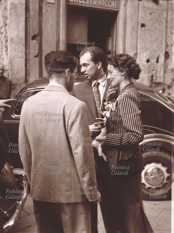 Ando GILARDI (1921-2012) e Luciana BARBARINO (1927-2014), il matrimonio dei fondatori della Fototeca Storica Nazionale: gli sposi appena usciti dalla sala comunale, intrattengono i pochi amici invitati per la semplice cerimonia. Fotografia amatoriale di anonimo, Genova 1950.