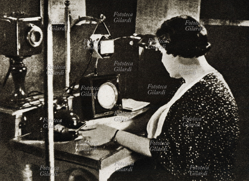 RADIO Annunciatrice mentre trasmette il segnale orario, uno dei primi servizi radiofonici. Italia anni 1930 - 1939