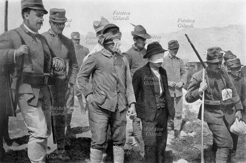 PRIMA GUERRA MONDIALE spie catturate dalla polizia militare. Gli imputati, uno dei quali molto giovane, si tengono per mano e sono condotti alla fucilazione bendati, attraverso un accampamento. Fotografia, aprile 1916