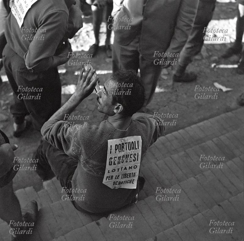 MANIFESTAZIONE pacifica: lavoratore seduto sui gradini beve in un momento di pausa e ristoro. \