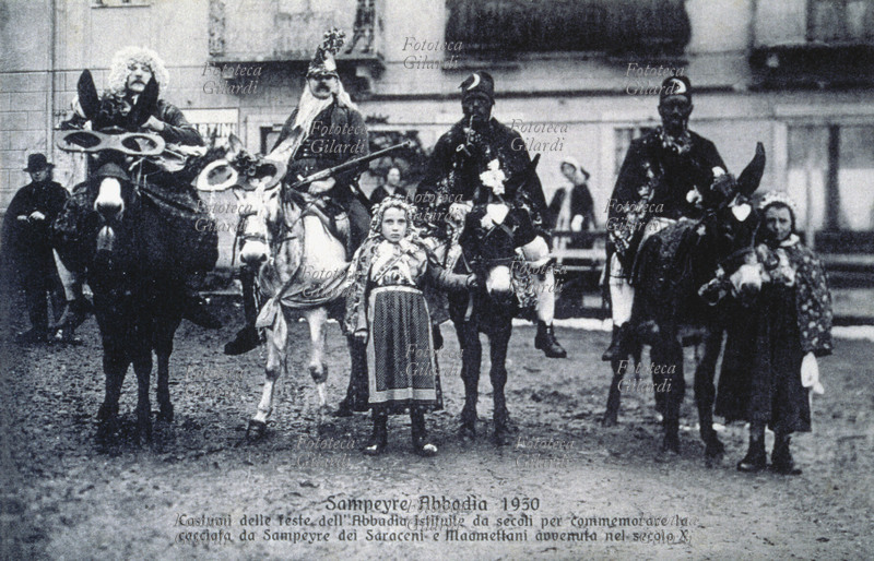 TRADIZIONI POPOLARI Baìo, Sampeyre 1930. Gruppo di quattro cavalieri a cavallo di asini e due bambine in posa: costumi delle feste dell\