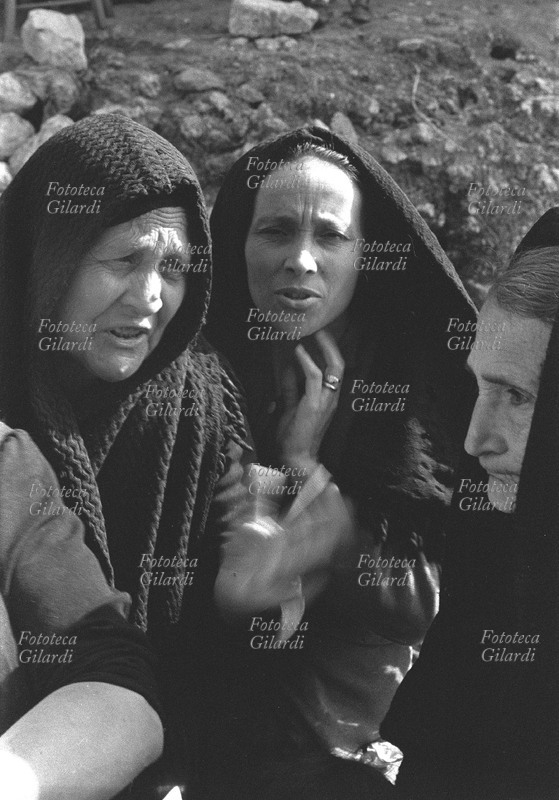 DONNA Gruppo di donne durante una discussione, i visi intensi incorniciati dal velo nero. Fotografia di Ando Gilardi (1921 - 2012) #andogilardi Palma di Montechiaro, 1955 circa.