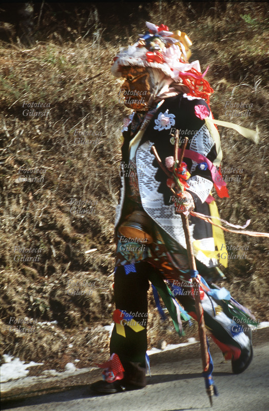 CARNEVALE di Valfloriana (Trentino). Matòcio sulla strada. I Matòci precedono il corteo degli Arlecchini, giungono uno alla volta al paese, preannunciati dal tintinnare del campanaccio che portano in vita, e vengono fermati dagli abitanti che li sottopongono al contrèst, un ridicolo contradditorio a tema erotico, volto a scoprire l\