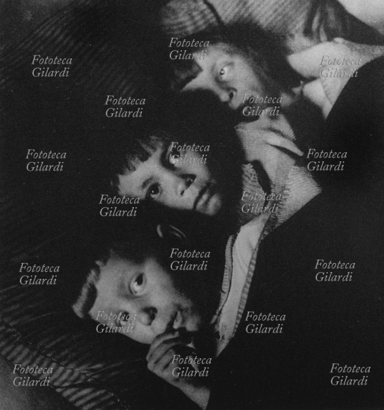 SHOAH Tre bambini ebrei si preparano per la notte nel loro letto della casa-nascondiglio in Amsterdam. In uno simile visse Anna Frank 18 mesi, prima di essere scoperta e deportata. Olanda, 1942