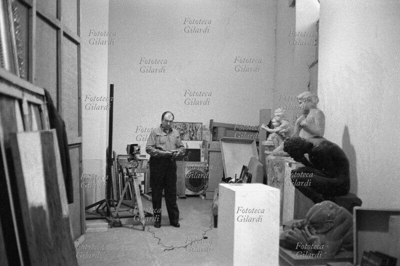 Ando GILARDI esegue riprese fotografiche nel deposito di un museo romano. Roma, 1963 .