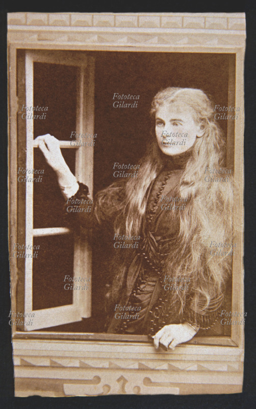 DONNA Ritratto di giovane donna con capelli biondi e lunghi sciolti sulle spalle. La ragazza è appoggiata all\