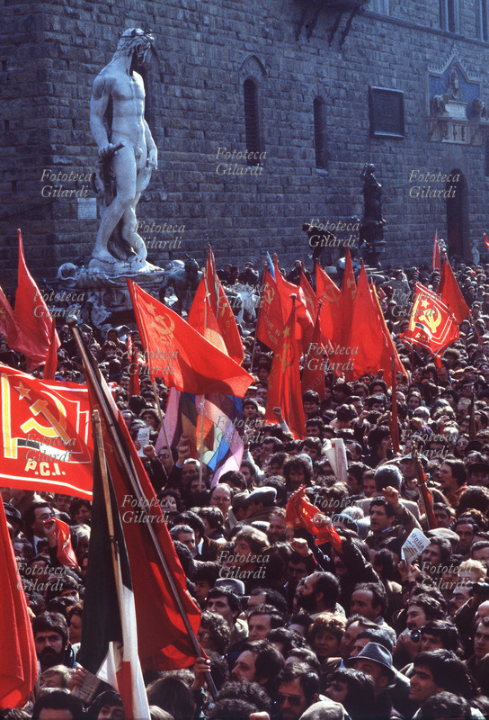 STORIA DEL MOVIMENTO OPERAIO Manifestazione commemorativa dei lavoratori per il Primo Maggio, molte le bandiere del P.C.I. davanti alla Fontana del Nettuno e Palazzo Vecchio in Piazza della Signoria a Firenze, 1970/75.