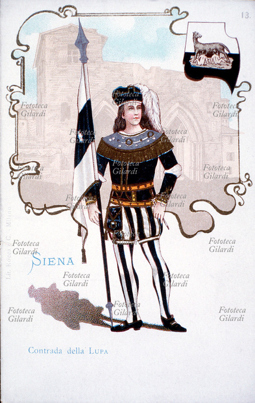 PALIO DI SIENA Sbandieratore della Contrada della Lupa, di cui si accenna un scorcio sullo sfondo. Costume tradizionale, stemma e bandiera della contrada in una cartolina postale, Italia primi anni del XX secolo.
