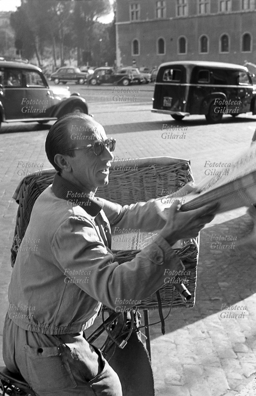 GIORNALI Fattorino distributore consegna in bicicletta i pacchi di giornali alle edicole. Fotografia di Ando Gilardi (1921 - 2012) #andogilardi, Roma 1954.