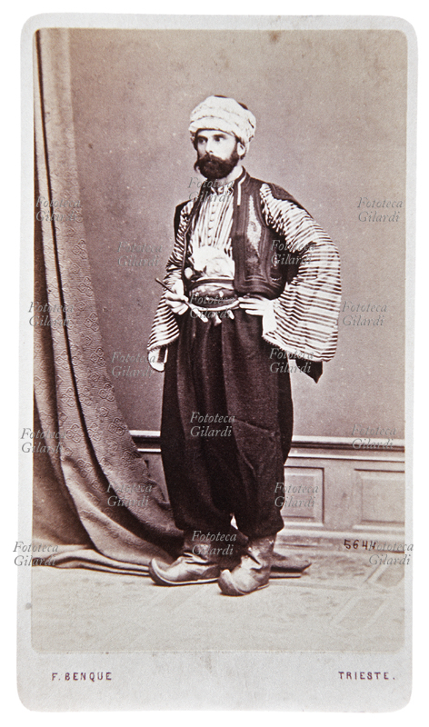 TRAVESTIMENTI giovane uomo in costume arabo, ritratto a figura intera. Fotografia virata seppia, F. Benque, Trieste 1890 circa.