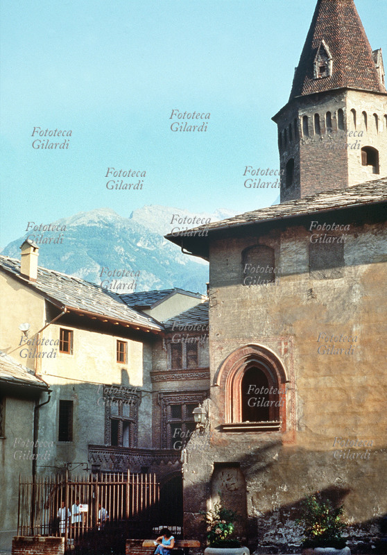 AOSTA veduta esterna laterale della Chiesa di S. Orso (994- 1025) e della collegiata (1133), sullo sfondo uno scorcio sul panorama montuoso alpino. Fotografia di Patrizia Piccini, Aosta 1991