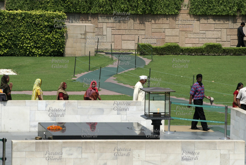 DELHI Raj Ghat: in riva al fiume Yamuna, è il luogo della cremazione del Mahatma Gandhi, avvenuta il 31 gennaio 1948. Gli indiani sfilano interrottamente di fronte a questo monumento commemorativo, una semplice lastra di marmo nero, per rendere omaggio al Padre della Patria. Fotografia di Raffaella Milandri. India, maggio 2007