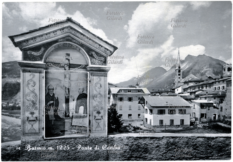 DEVOZIONE POPOLARE edicola votiva sul Ponte di Combo, nei pressi di Bormio (SO). Una rete di protezione posta davanti alla parte inferiore del dipinto spezza poco dignitosamente in due la figura del crocifisso. Cartolina postale, Italia 1950 circa