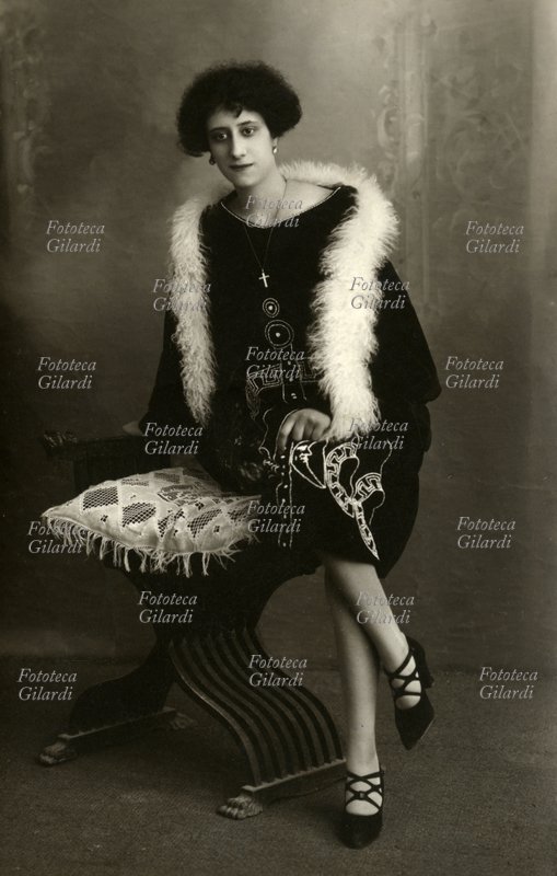 MODA Giovane elegante signora posa informalmente seduta sul bracciolo di una \