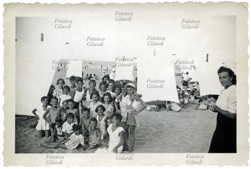 VACANZE spiaggia riservata a una delle prime colonie aziendali organizzata per i figli dei dipendenti di aziende private. Foto di gruppo di ragazzini, sullo sfondo le tende per la sosta all\