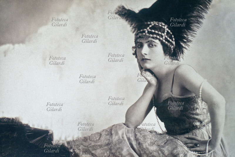Francesca Bertini (1892) actress. Debuts in theatre in a Neapolitan dialectal company, passed to the cinema not still twenty-year-old. Its reputation of beautiful and fatal woman gave origin to the divismo in Italy. In this portrait it wears an evening dress with a hat of ostrich pens. Italy, 1915-20.