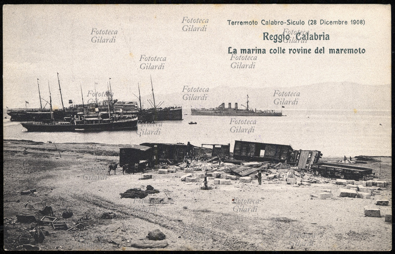 TERREMOTO Calabro-Siculo del 1908. Reggio Calabria, la marina colle rovine del maremoto. Il terribile sisma di magnitudo 7,2 ha contato fra le 90.000 e le 120.000 vittime in tutta la zona colpita. Cartolina postale da una serie edita dalla Croce Rossa a sottoscrizione per i terremotati, sistema mediatico pionieristico per la raccolta dei fondi a favore delle vittime di catastrofe naturale, che nell\