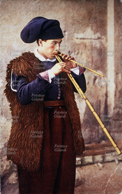 SUONATORE di Launeddas a S. Antioco, Sardegna (Italia), in costume tradizionale. Fotocromia, Terni 1910 circa.