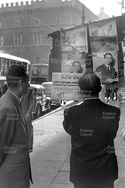 INFORMATION Passers-by look at newspapers displayed on a newsstand to attract their attention and encourage them to buy the day\