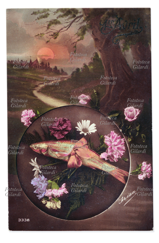 RICORRENZE Primo Aprile, composizione allegorica. Un vero pesce in mezzo ad una composizione di fiori freschi, passe-partout tondo sullo sfondo di un sentiero di campagna. Cartolina fotografica acquarellata. Francia, 1915 circa.