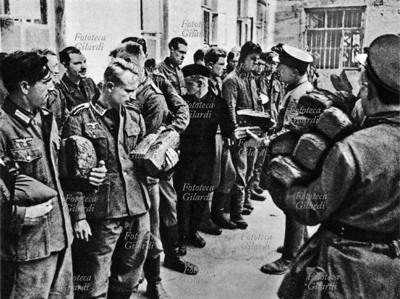 WWII German soldiers in a Soviet prison camp, receive their food ration from officers and Russian soldiers. USSR 1945