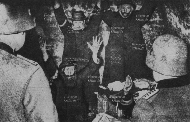 II G.M. NAZISMO alcuni soldati tedeschi scoprono un nascondiglio di ebrei, probabilmente denunciati dai vicini di casa. Sorpresi, si arrendono alzando le mani: si nascondevano per sfuggire alla cattura e alla deportazione verso i campi di sterminio, cioè alla morte. Chi \