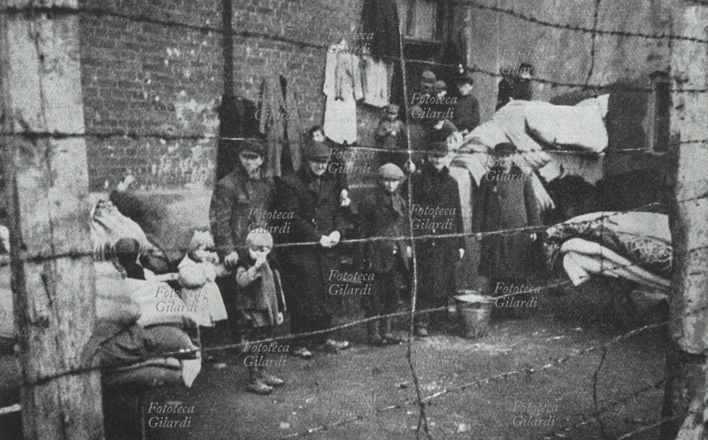 GHETTO DI ZYCHLIN il ghetto di Zychlin, circondato dal filo spinato. Bambini ed adulti in posa oltre il recinto, davanti alla loro casa-negozio. Polonia (?), 1939 - 1941