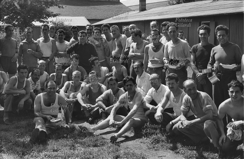 EMIGRATION Group of Italian workers photographed in the foreground, in front of the barracks used as homes for bachelors, or for men without families following them. Photograph by Ando Gilardi (1921-2012) #andogilardi, Dachau 1954 - 1955.