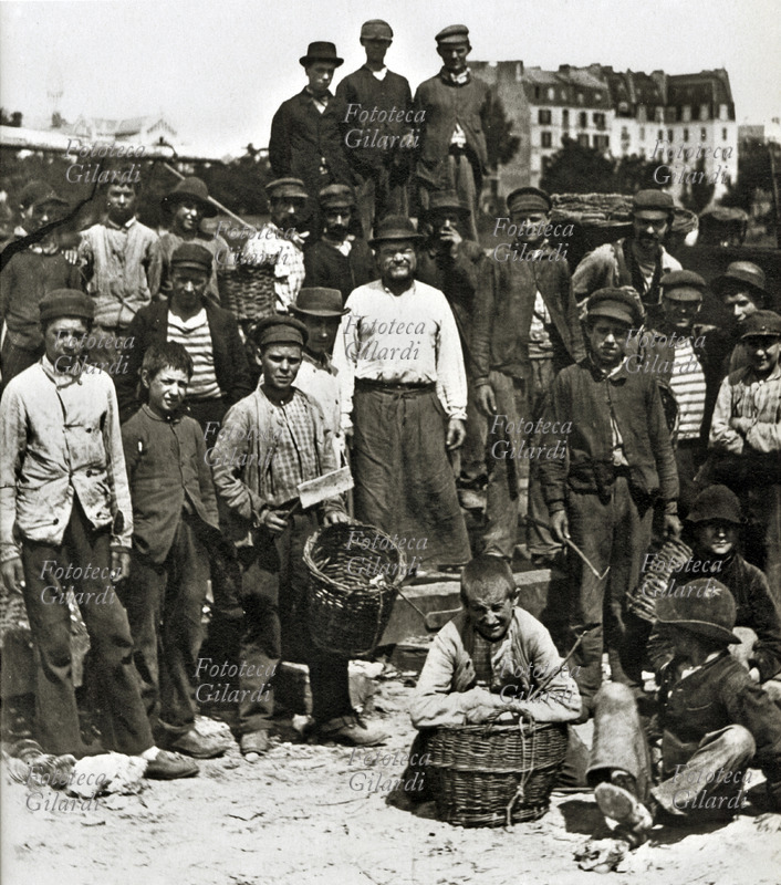 MESTIERI Gruppo fotografico di straccivendoli. In primo piano posano i ragazzini e al centro gli adulti che gestiscono e organizzano il lavoro. Parigi, 1890 circa.