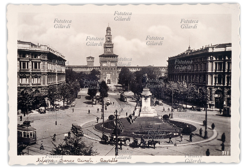 MILANO Largo Cairoli e Piazza Castello. Intorno al monumento centrale il parcheggio delle carrozze e dei taxi. Cartolina fotografica, Milano 1935.