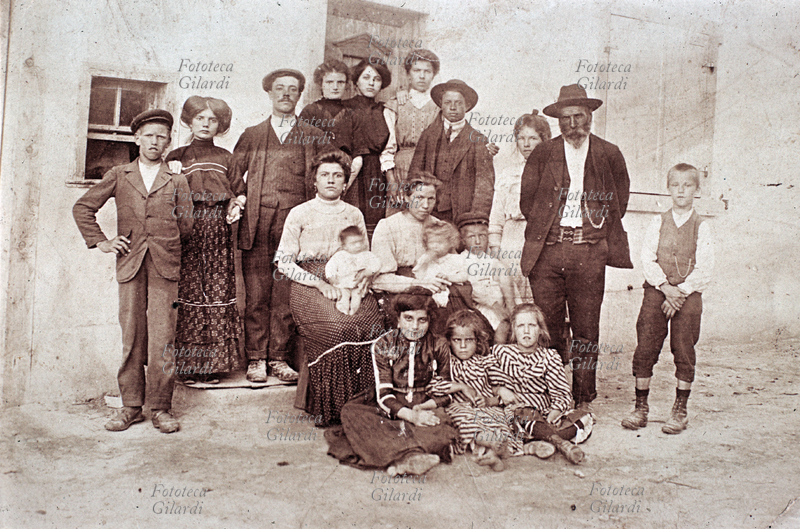 FAMIGLIA gruppo di famiglia numerosa, al centro in grembo alle madri i bambini più piccoli, con il viso inevitabilmente mosso, per la lunga posa. Fotografia ricordo dei primi anni del 1900