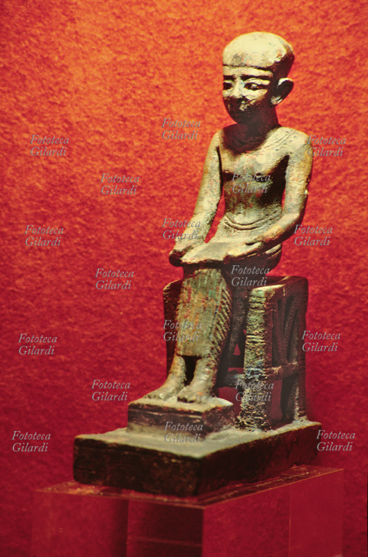ANTICO EGITTO statuina di Imhotep; il dio è rappresentato seduto, con un papiro aperto sulle ginocchia. Bronzo, provenienza ignota, epoca tarda.